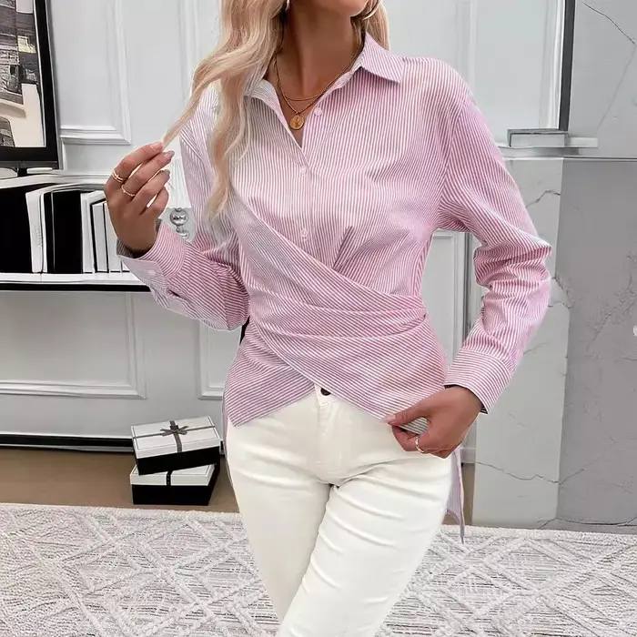 La chemise asymétrique à manches longues à rayures verticales bleues et blanches pour femmes comprend un design torsadé distinctif et à la mode
